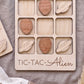 A wooden tic-tac game board with wooden alien and spaceship tiles, and the word "TIC-TAC-ALIEN" printed on it.