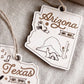 two wooden ornaments shaped like the state of Arizona, with various symbols and text related to the state.