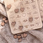 a wooden bingo board with various heart-shaped stickers attached to it, along with some additional heart-shaped stickers scattered around the board.