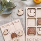 a wooden tic-tac game with various vehicles, including a truck, car, and duck, as well as a wooden teddy bear. The game appears to be made of wood and has a tic-tac grid with wooden pieces.