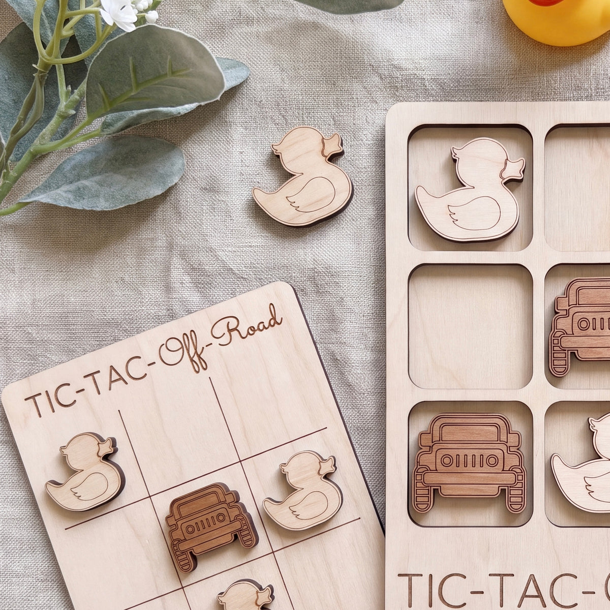 a wooden tic-tac game with various vehicles, including a truck, car, and duck, as well as a wooden teddy bear. The game appears to be made of wood and has a tic-tac grid with wooden pieces.