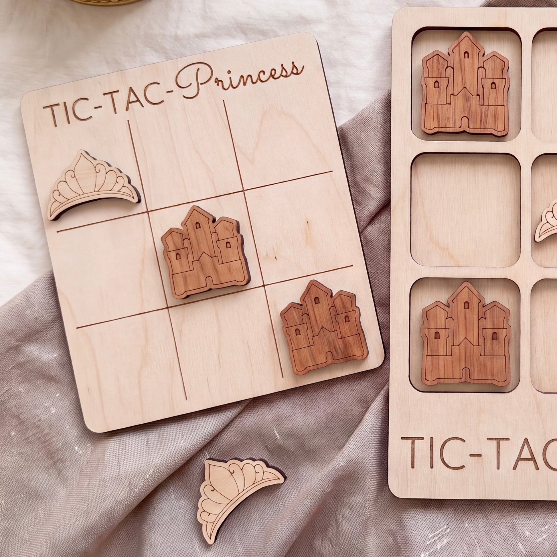 a wooden tic-tac game board with wooden pieces shaped like castles, and a wooden tic-tac game board with wooden pieces shaped like crowns.