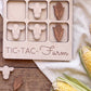 a wooden game board with a farm theme, along with some corn and cow-shaped cutouts.