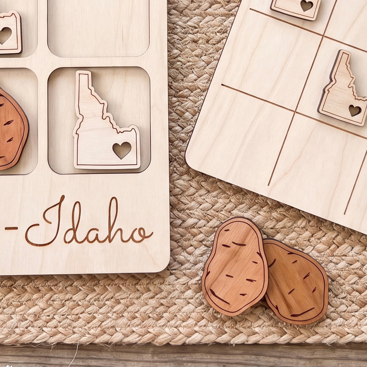 a wooden game board with a potato cutout and the word "Idaho" written on it. There are also two wooden potato cutouts on the ground.