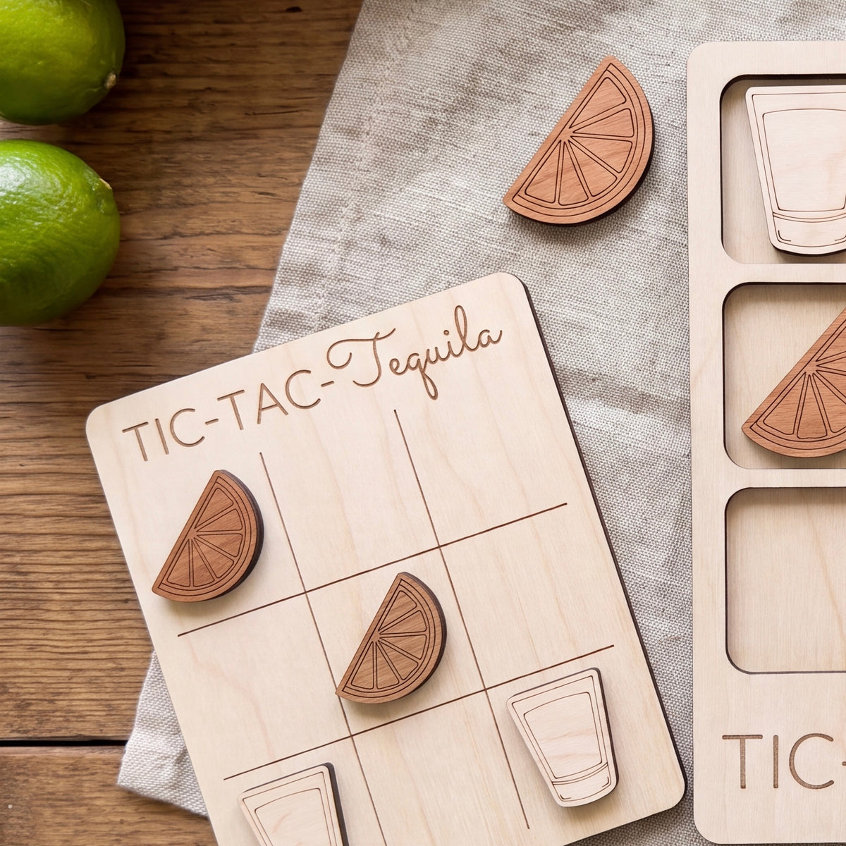 a wooden tic-tac game board with wooden cutout pieces shaped like tequila glasses and limes, placed on a wooden surface.
