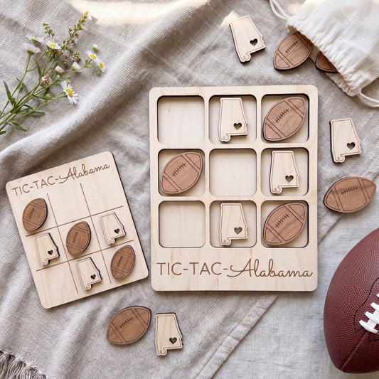 a wooden Tic-Tac- Alabama game board and several wooden Tic-Tac- Alabama game pieces arranged on a beige cloth.