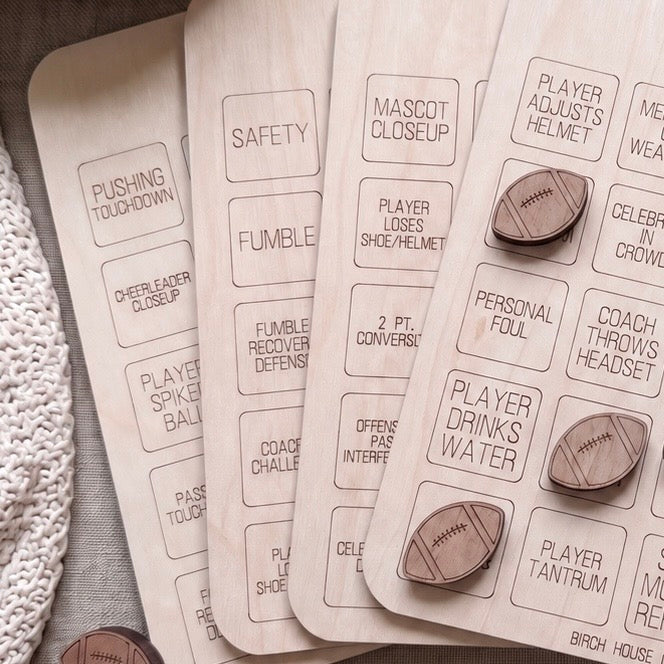 a collection of wooden game pieces, each with a label, likely representing different aspects of a game or activity.