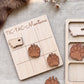 a wooden tic-tac game board with a Minnesota state shape cutout, along with several wooden paw print shapes.