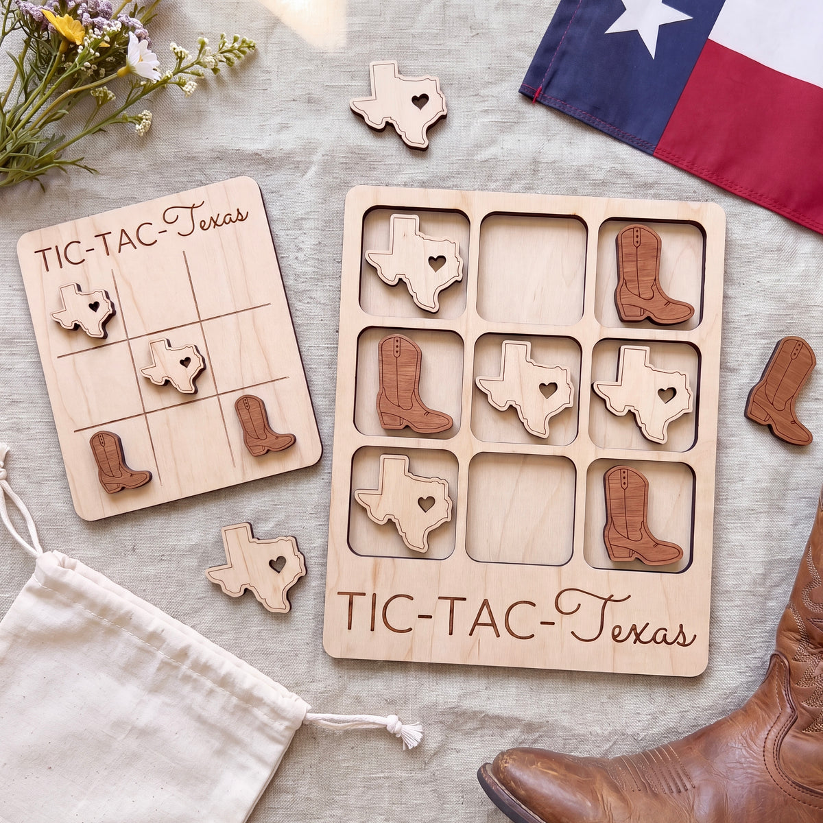 a wooden Tic-Tac-Texas game board with wooden tiles shaped like Texas state icons, along with a pair of brown boots and a Texas flag.