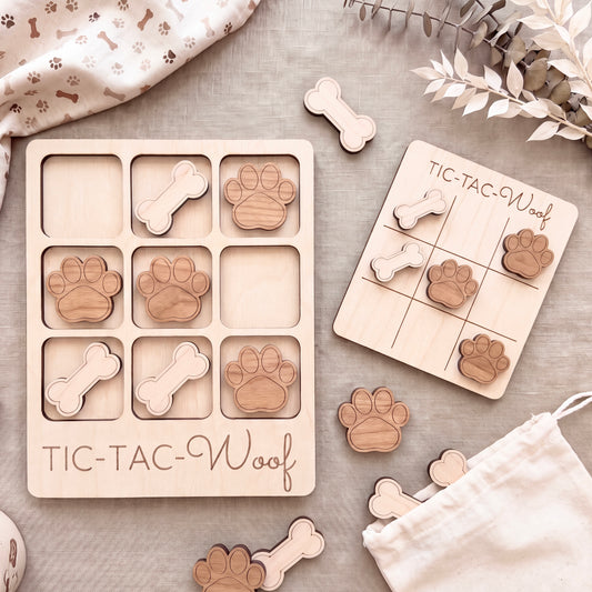 a wooden tic-tac-toe game with wooden dog paw tiles and a wooden tic-tac-toe game board.