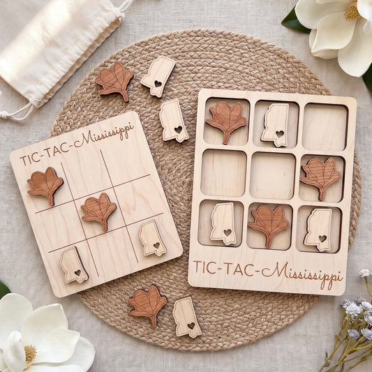 a wooden tic-tac game with wooden pieces shaped like leaves and hearts, placed on a woven placemat.