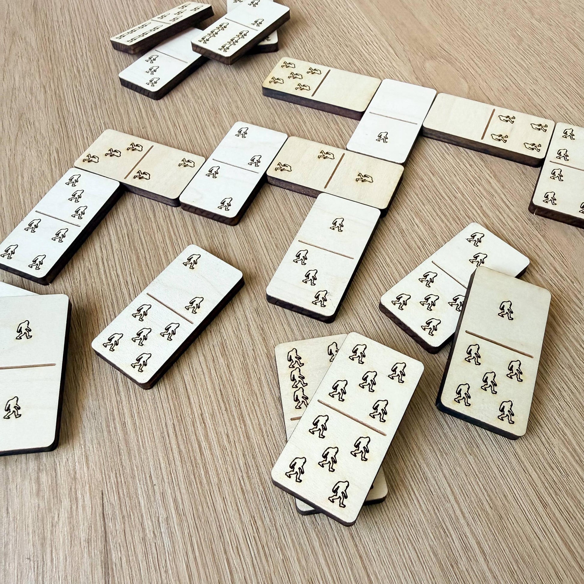 a collection of wooden dominoes arranged on a wooden surface.