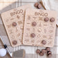 two wooden golf bingo boards with various golf-related words and phrases written on them, along with several wooden golf balls scattered around.