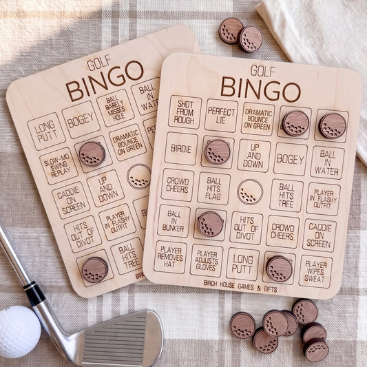 two wooden golf bingo boards with various golf-related words and phrases written on them, along with several wooden golf balls scattered around.