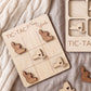 a wooden tic-tac game board with wooden pieces shaped like states in the United States, including New York.