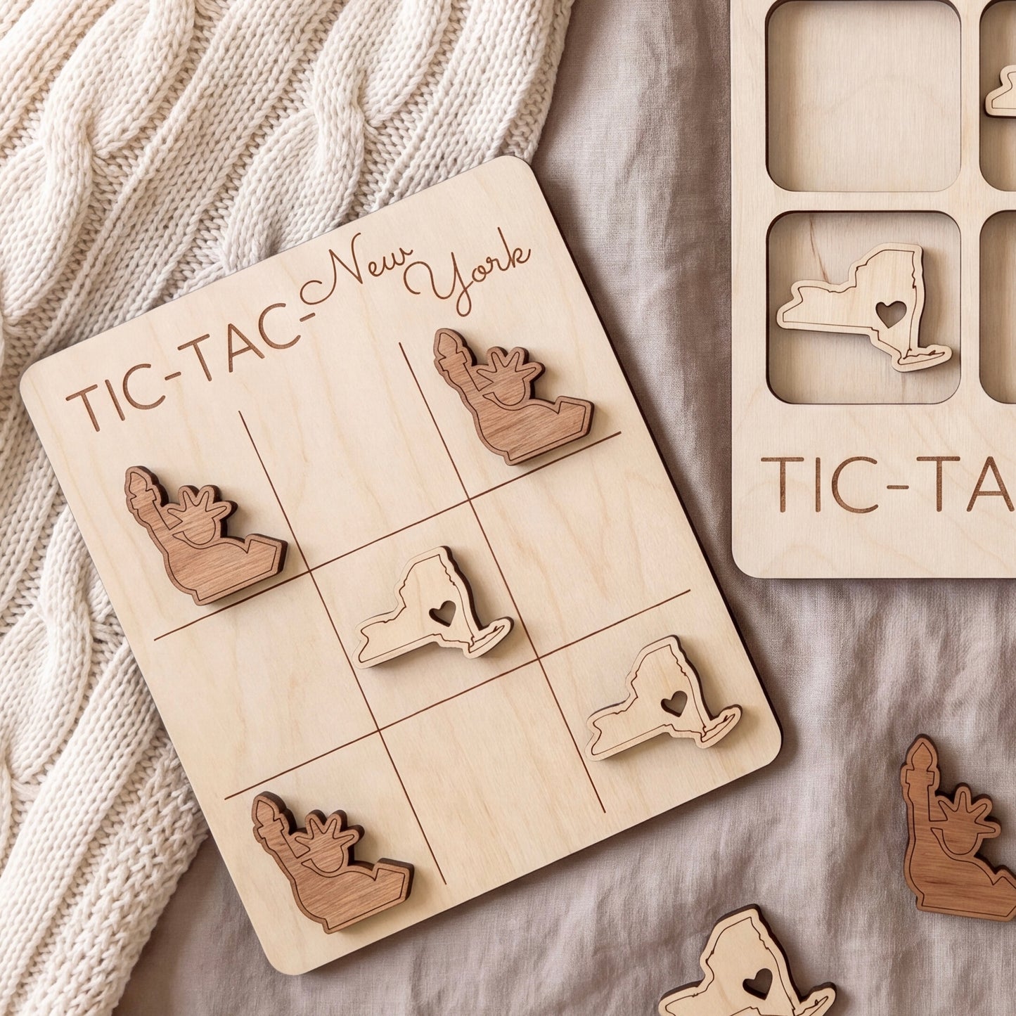 a wooden tic-tac game board with wooden pieces shaped like states in the United States, including New York.
