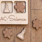 a wooden puzzle board with various science-themed pieces, including a molecule, a flask, and a star.