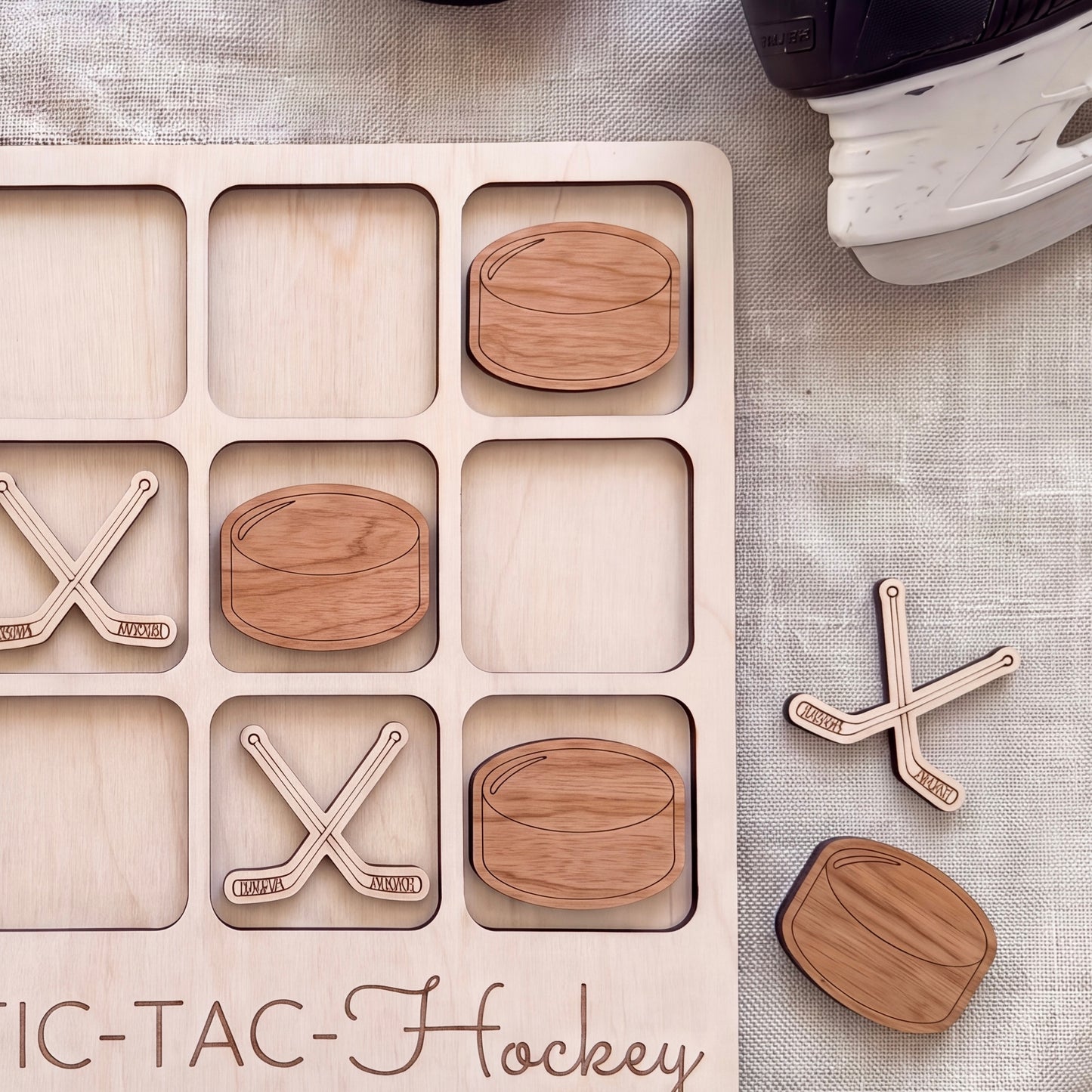 A wooden tic-tac game board with wooden hockey sticks and wooden hockey balls, along with a black and white hockey helmet.