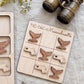 A wooden tic-tac game board with whale-shaped tiles, accompanied by a pair of binoculars and some flowers on a table.