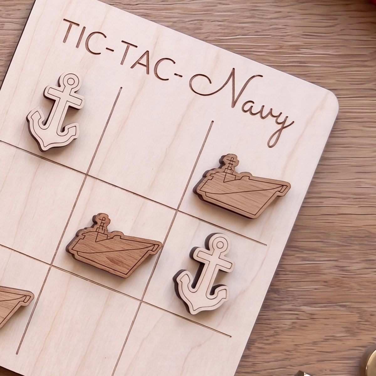 A wooden tic-tac game board with wooden tic-tac pieces shaped like anchors, labeled "TIC-TAC-Navy".