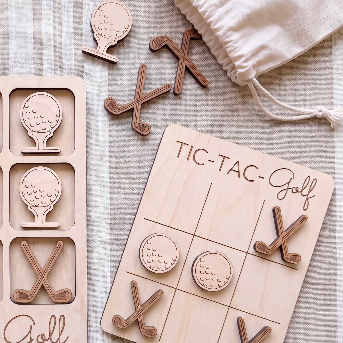 a wooden tic-tac game with golf-themed tiles and wooden golf clubs, as well as a white drawstring bag.