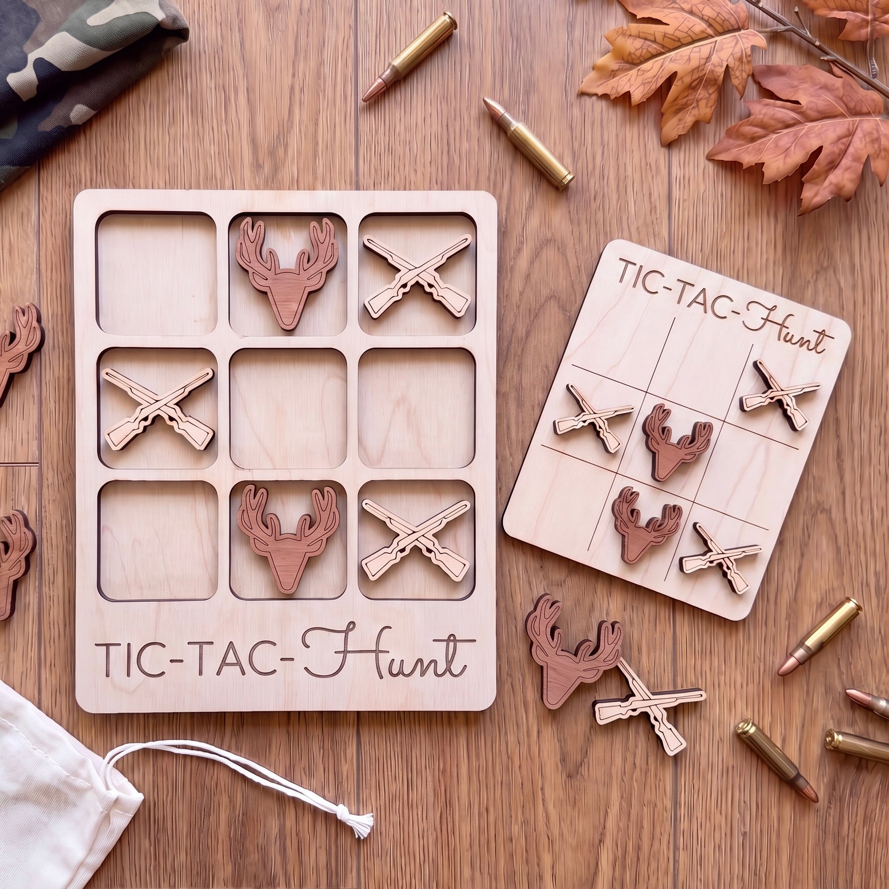 a wooden tic-tac game with deer heads and cross-shaped pieces, along with some bullet casings on a wooden surface.