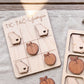 A wooden tic-tac game board with wooden pieces shaped like the states of Georgia, including a peach and an apple.