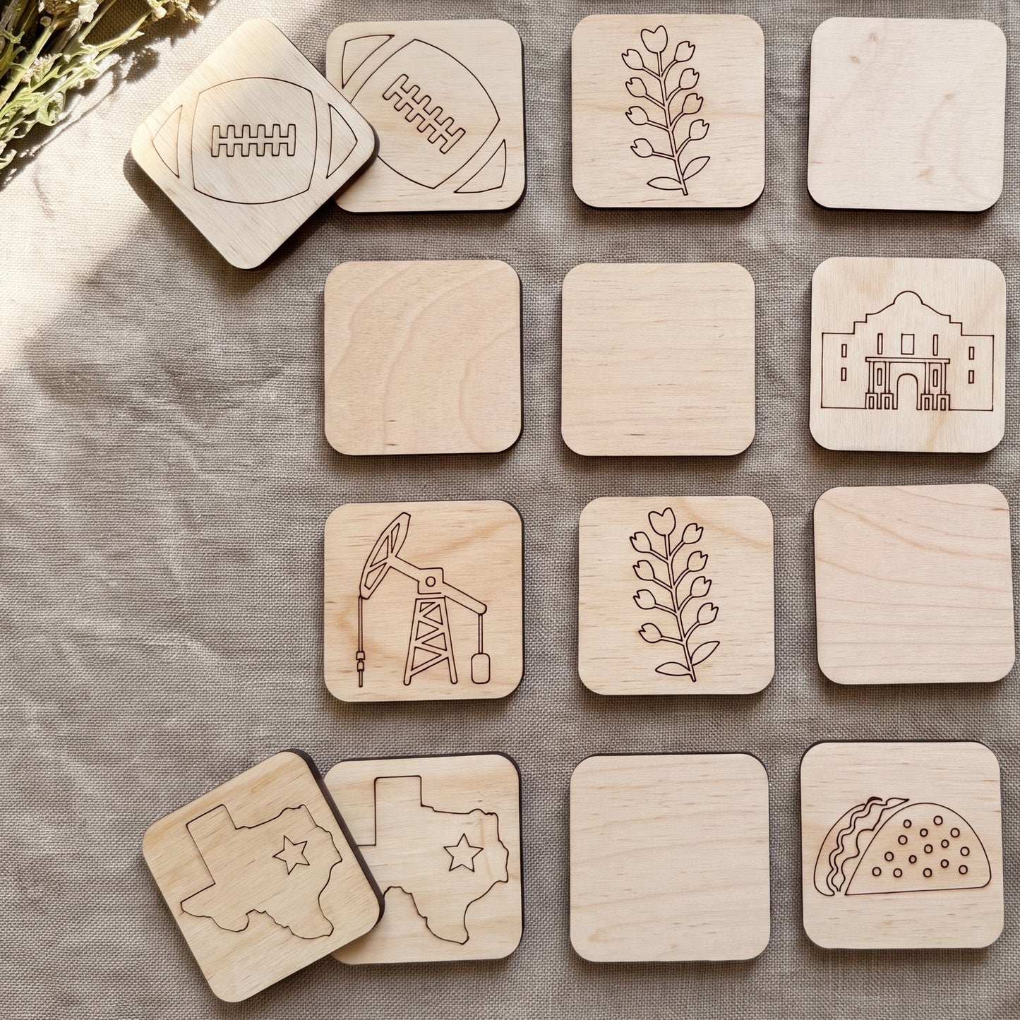 a collection of wooden coasters featuring various designs, including a football, a plant, a building, an oil pump, a star, a taco, and a flower.