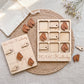 a wooden Tic-Tac-Kentucky game set, including a game board and wooden pieces shaped like horses. The game board is placed on a woven placemat, and there are some wooden pieces scattered around the board.