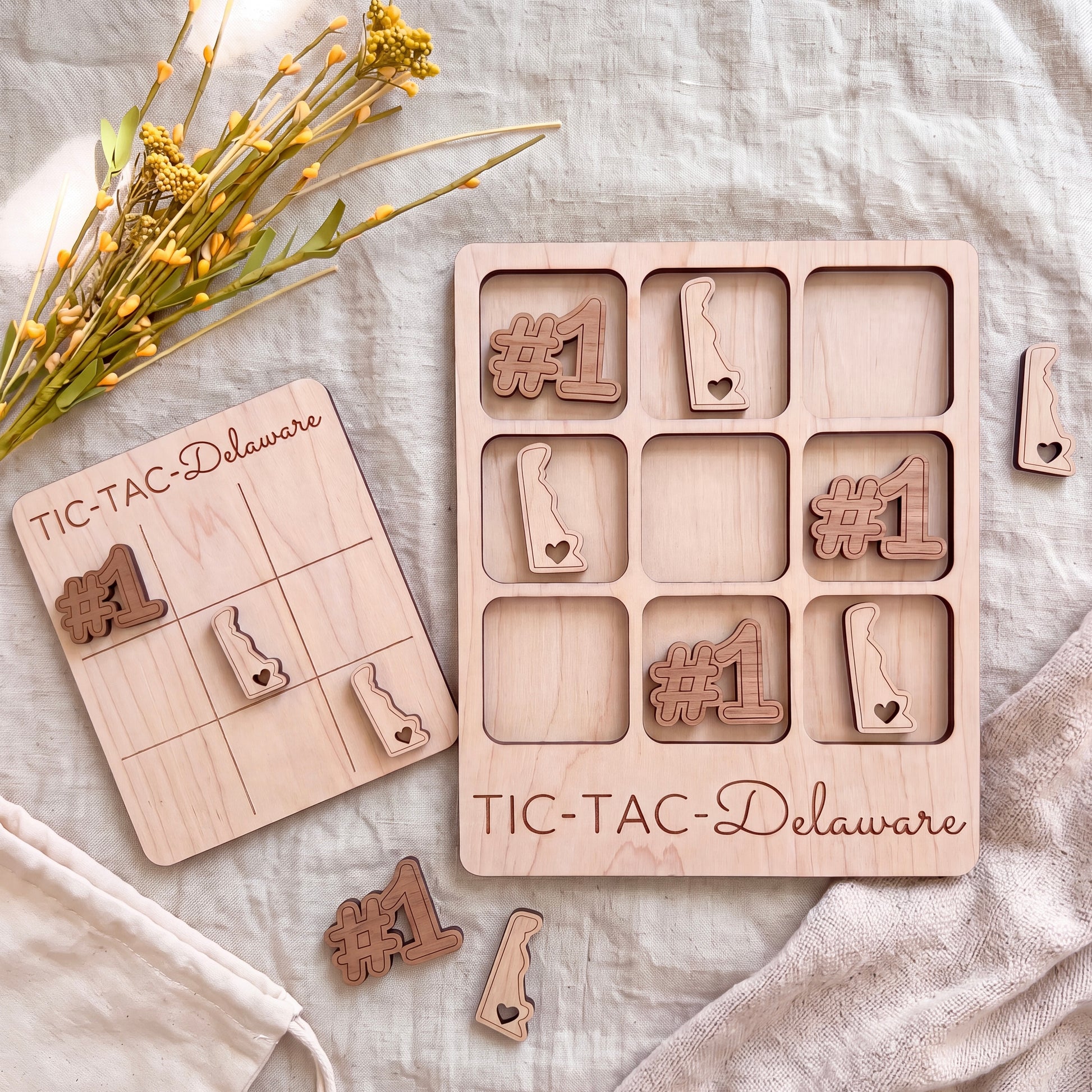 a wooden tic-tac game board and wooden pieces with the text "TIC-TAC-Delaware" printed on them.