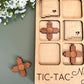 a wooden tic - tac - toe board next to a flower