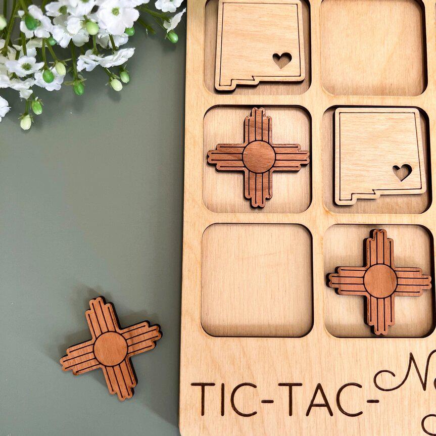 a wooden tic - tac - toe board next to a flower