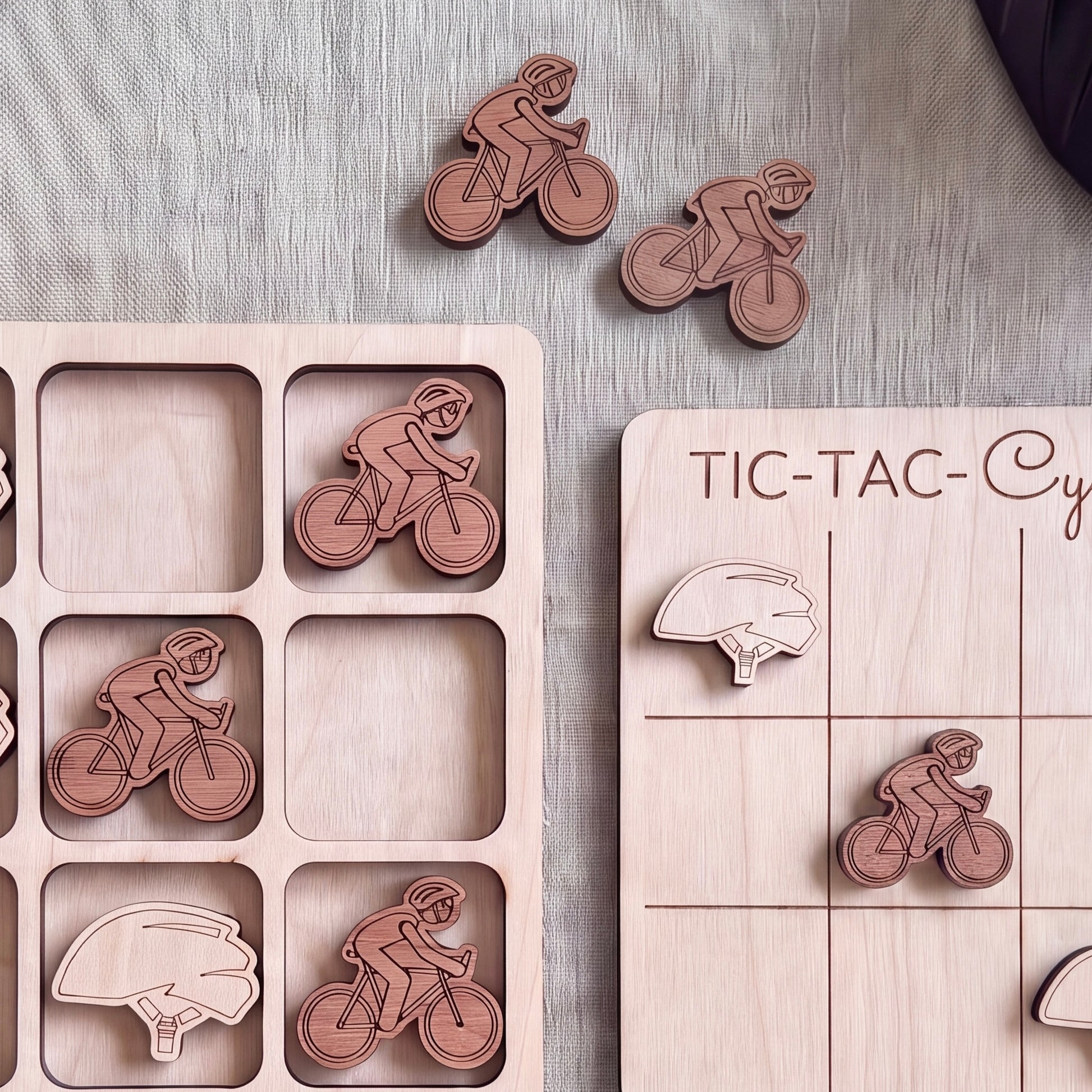 a wooden game board with a tic-tac game board and several wooden tic-tac pieces depicting bicycles and helmets.