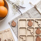 a wooden teddy bear with a Florida state on it, a bowl of oranges, a bouquet of flowers, and a wooden game board with Florida state stickers.