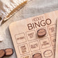 A wooden bingo board with various hockey-related words and symbols, including "OFFSIDES", "SHOOT OUT", "HOME TEAM GOAL", "DELAYED PENALTY", "HIGH STICKING", and "FACE-OFF".