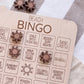 A wooden bingo board with various game elements and instructions, including a sun-shaped bingo piece and some wooden star-shaped pieces.