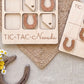 a wooden tic-tac game with wooden horseshoes and the word "TIC-TAC-New Mexico" written on it. There is also a woven basket and some flowers in the background.