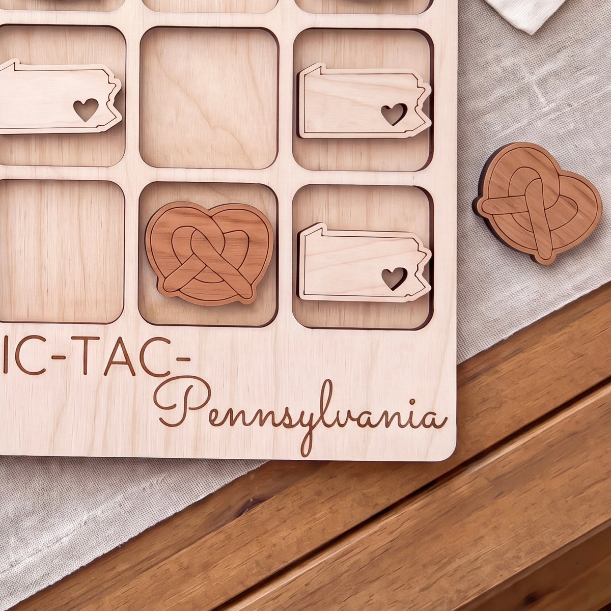 a wooden game board with a tic-tac game, specifically a Pennsylvania-themed game board.