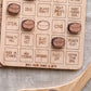 a wooden game board with various hockey-related terms and symbols, including penalties, shots, and team goals.