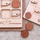 a wooden game board with a tic-tac-toe game set up, along with wooden game pieces shaped like the state of Tennessee.