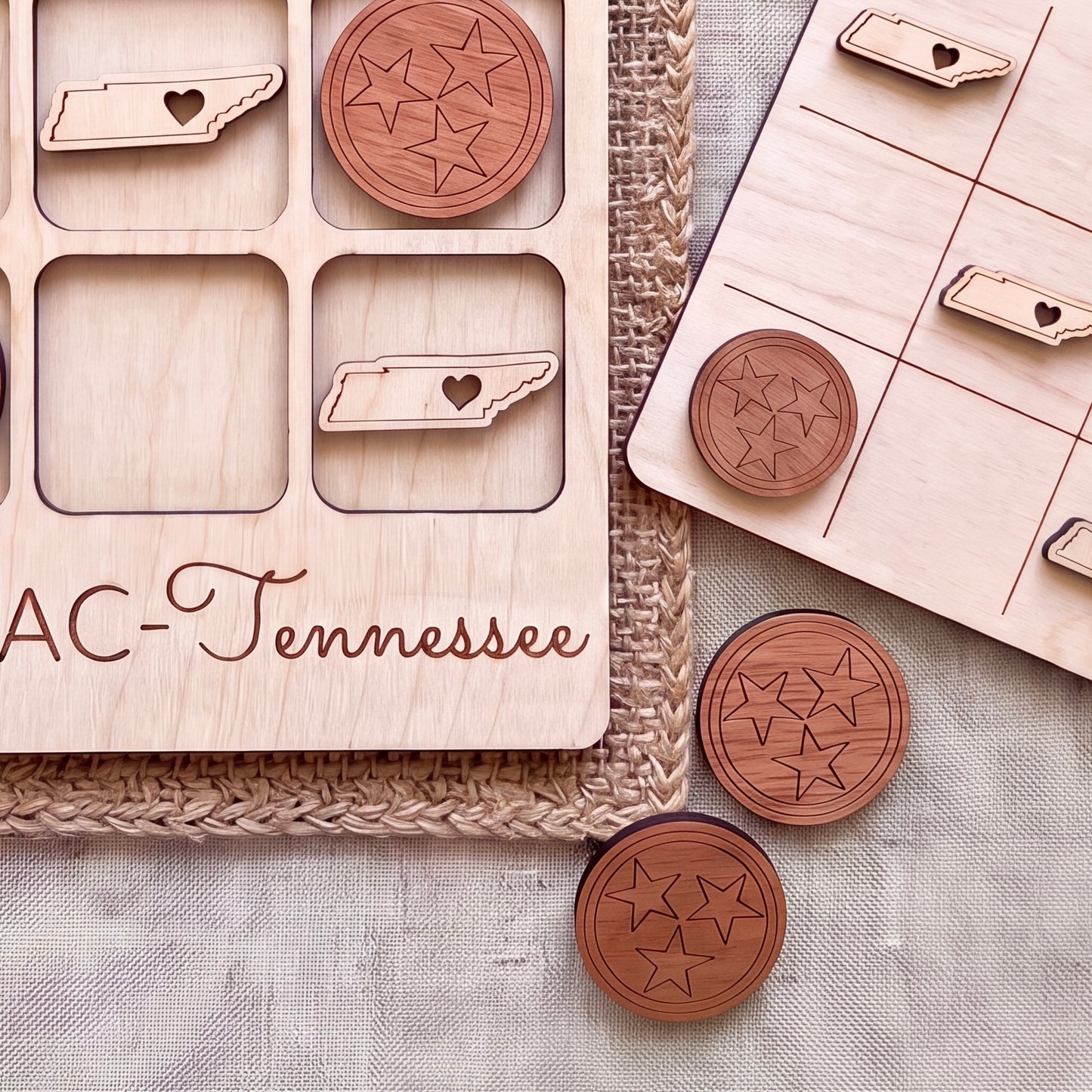 a wooden game board with a tic-tac-toe game set up, along with wooden game pieces shaped like the state of Tennessee.