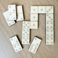 a collection of wooden dominoes arranged on a wooden surface.