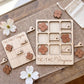 a wooden Tic-Tac game board and wooden pieces shaped like flowers, specifically from Virginia, placed on a wooden surface.