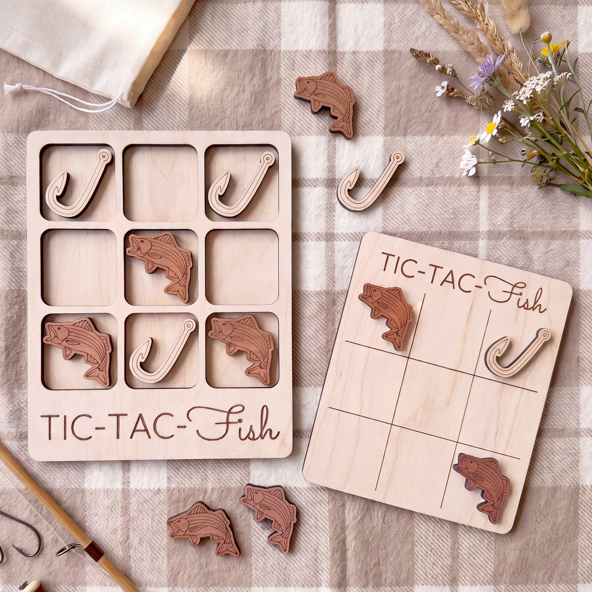 a wooden game board and a wooden puzzle with fish-shaped pieces, both placed on a checkered cloth.