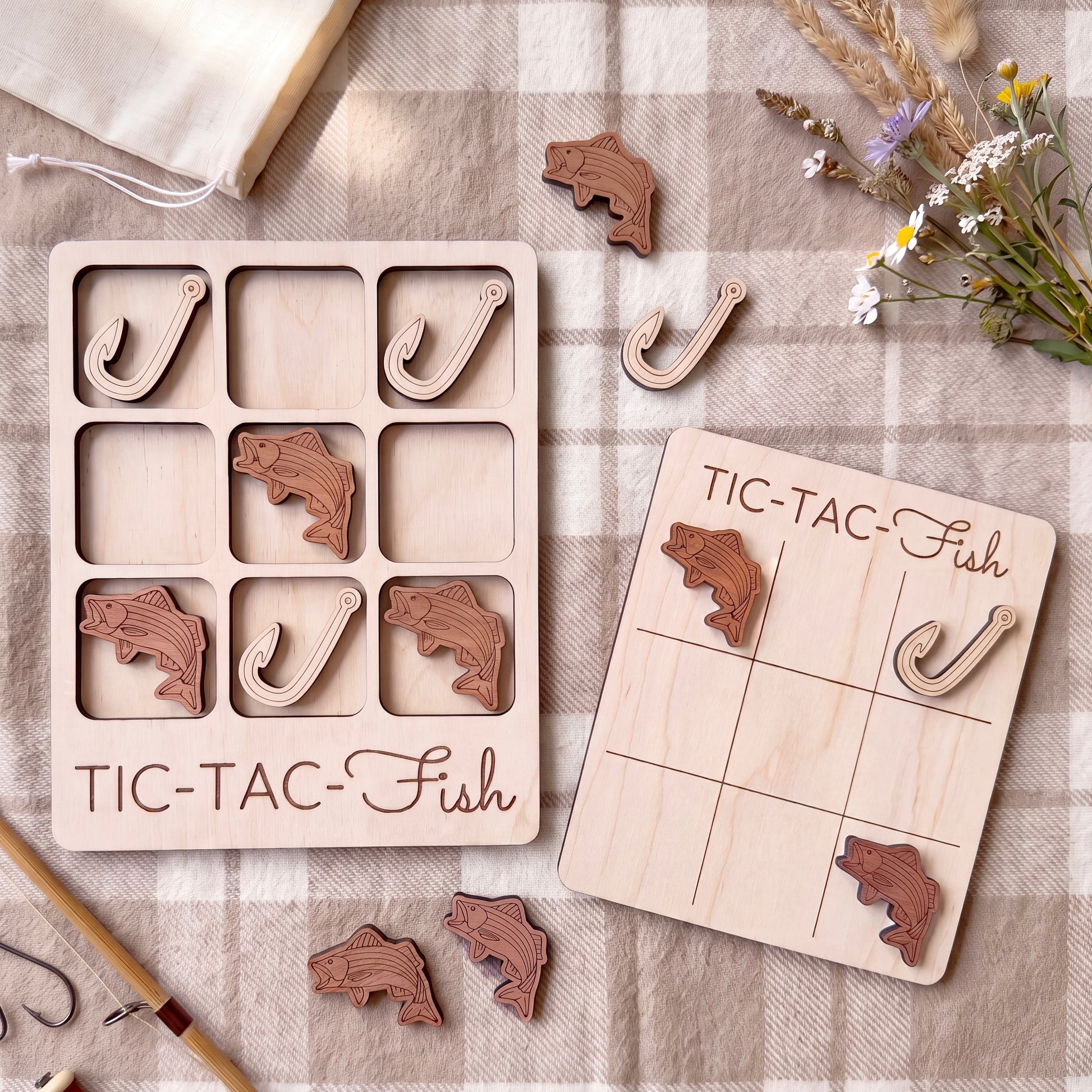 a wooden game board and a wooden puzzle with fish-shaped pieces, both placed on a checkered cloth.