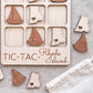 a wooden tic-tac game board with wooden pieces shaped like the states of Rhode Island, including a sailboat and a heart-shaped piece.