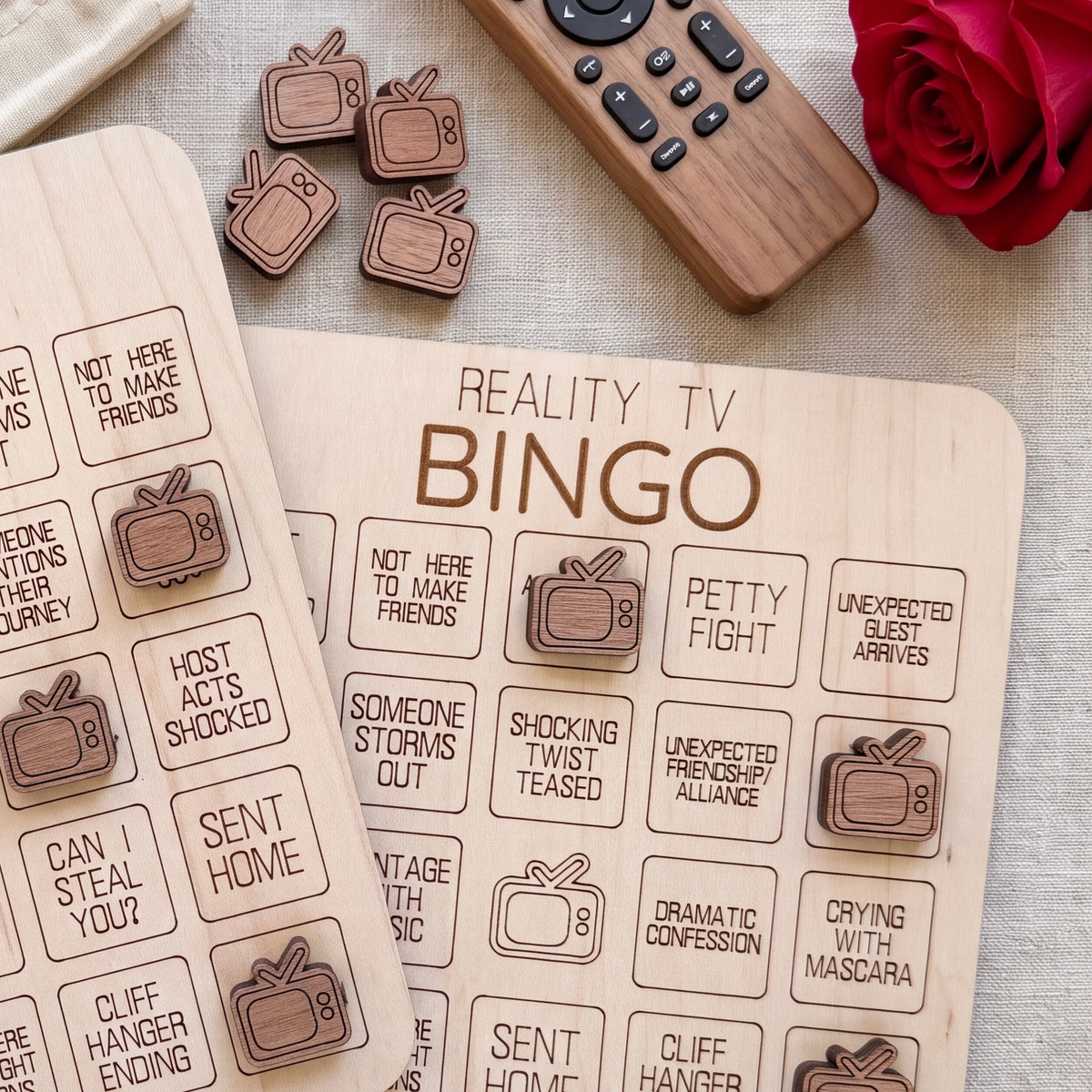 a wooden bingo board with various phrases and a remote control on a table.
