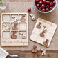 a wooden tic-tac game set with wooden cherries and a bowl of cherries, along with a wooden placemat and a vase of flowers.