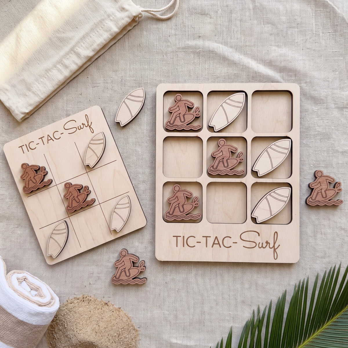 a wooden game board and several wooden pieces, including a game board and a set of wooden figures, all related to the game "TIC-TAC-Surf".
