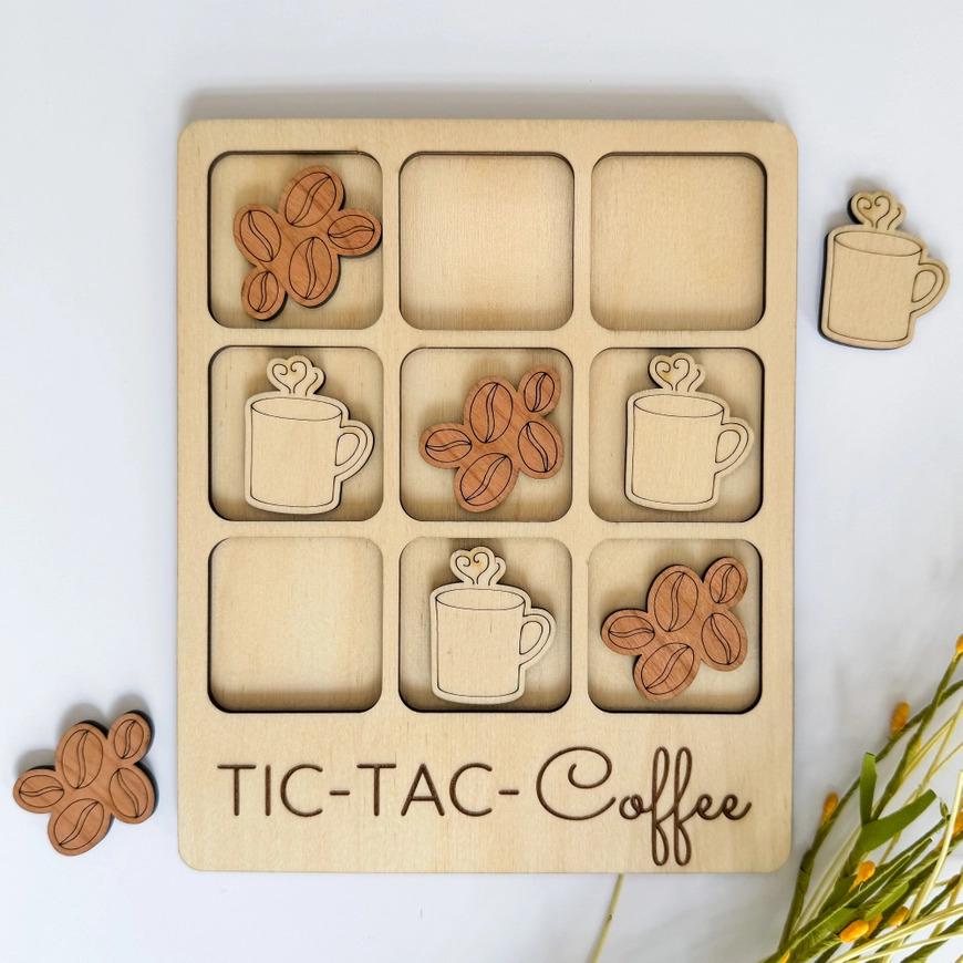 a wooden tic - tac - coffee tray with coffee cups and cinnamons
